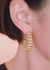 Gold hoop earrings worn by a person with blurred background